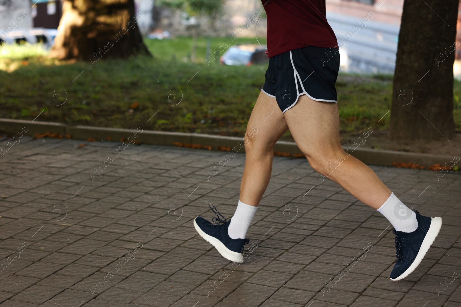Athletic young man in sportswear running outdoors, closeup. Space for text Photo of Athletic young man in sportswear running outdoors, closeup. Space for text