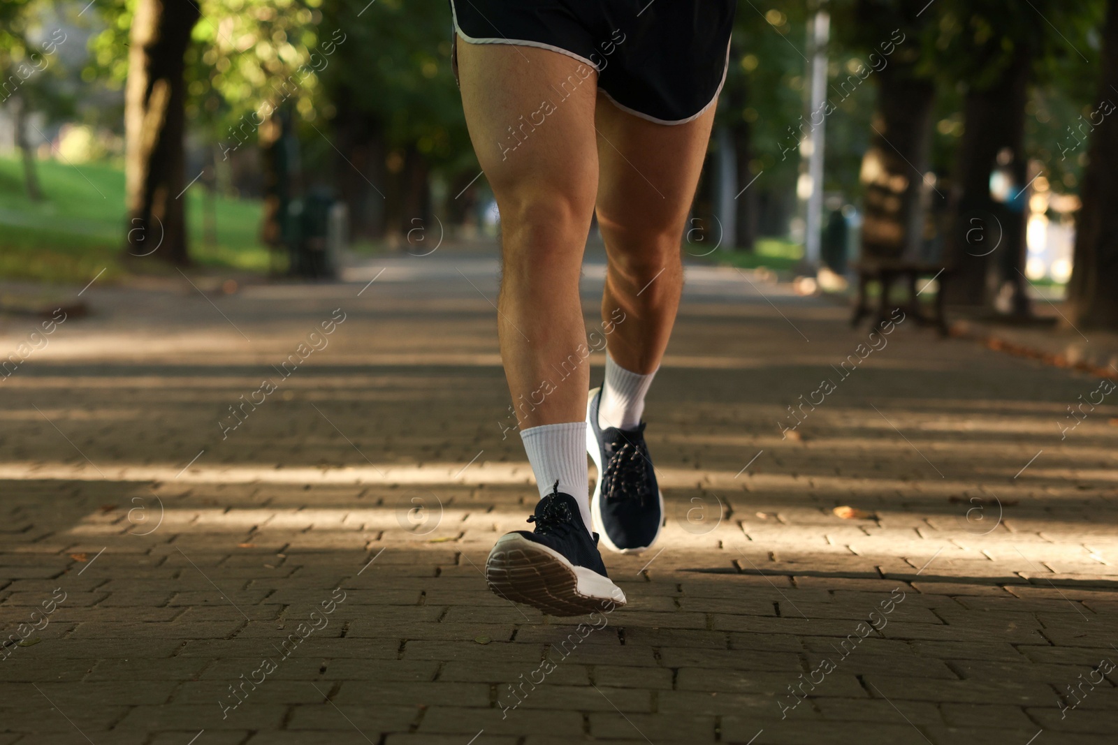 Athletic young man in sportswear running outdoors, closeup Photo of Athletic young man in sportswear running outdoors, closeup