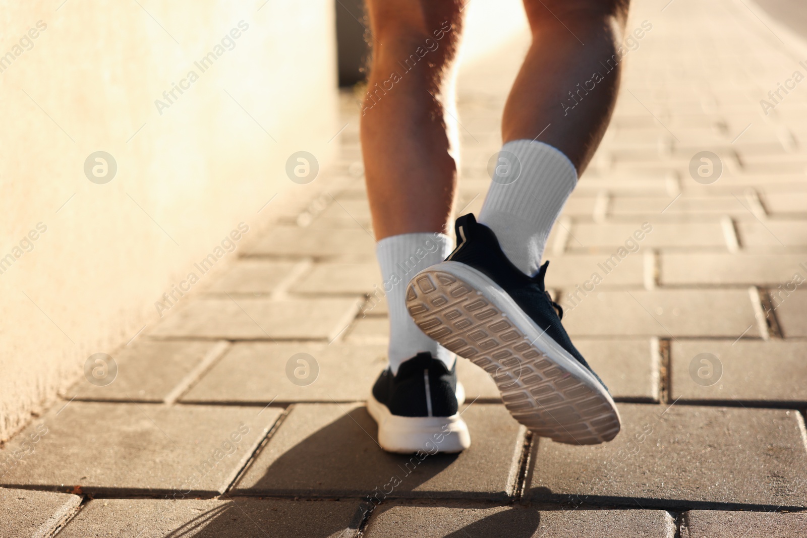 Athletic young man in sportswear running outdoors, closeup. Space for text Photo of Athletic young man in sportswear running outdoors, closeup. Space for text