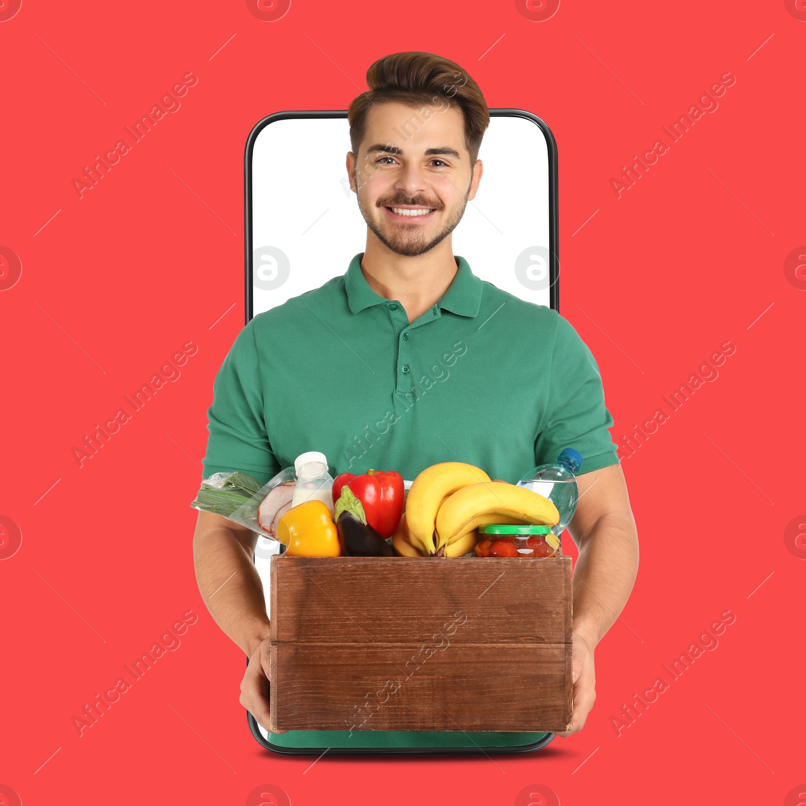 Delivery service worker giving order out of mobile phone against red background. Man with crate full of food products Image of Delivery service worker giving order out of mobile phone against red background. Man with crate full of food products