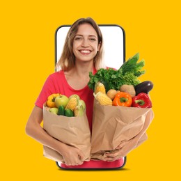 Image of Delivery service worker giving online order out of mobile phone against orange background. Woman with paper bags full of food products