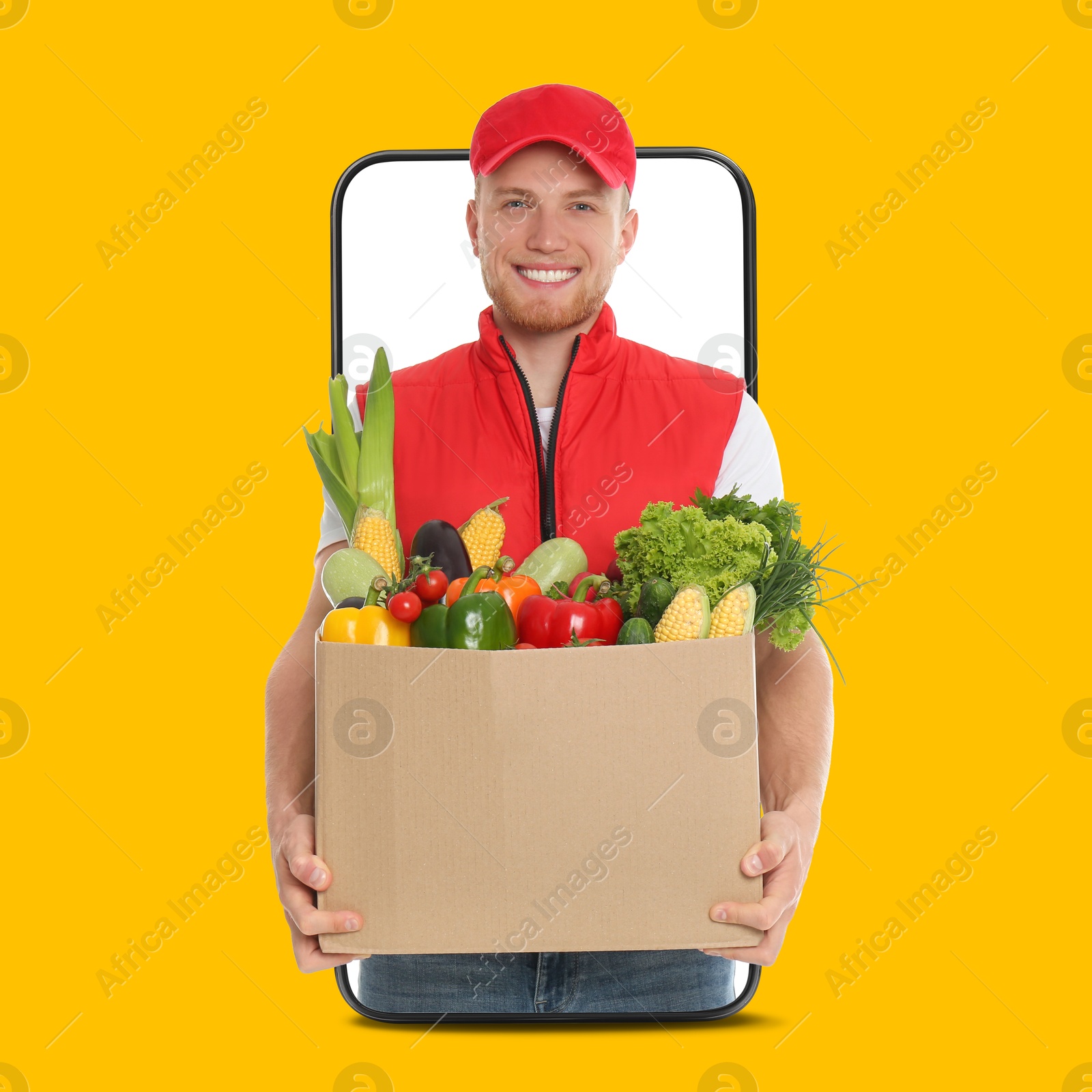 Delivery service worker giving online order out of mobile phone against orange background. Man with box full of food products Image of Delivery service worker giving online order out of mobile phone against orange background. Man with box full of food products