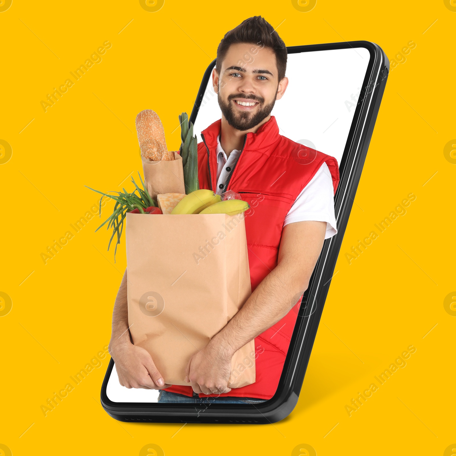 Delivery service worker giving online order out of mobile phone against orange background. Man with paper bag full of food products Image of Delivery service worker giving online order out of mobile phone against orange background. Man with paper bag full of food products