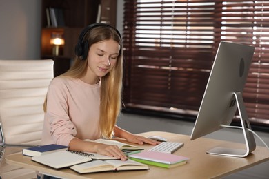 Photo of Teenage girl studying online at table indoors