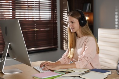 Photo of Teenage girl studying online at table indoors