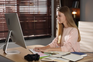 Photo of Teenage girl studying online at table indoors