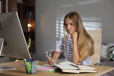 Photo of Teenage girl studying online at table indoors