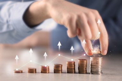 Image of Man stacking coins at table, closeup. Graph with arrows above stacks