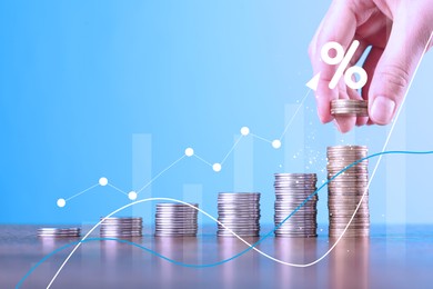 Image of Woman stacking coins at table, closeup. Graphs and percent sign above stacks