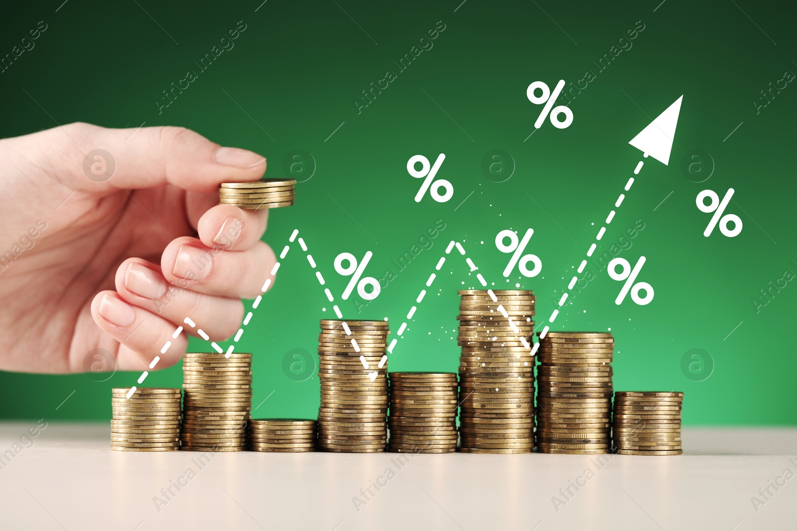 Woman stacking coins at table, closeup. Percent signs and arrow above stacks Image of Woman stacking coins at table, closeup. Percent signs and arrow above stacks