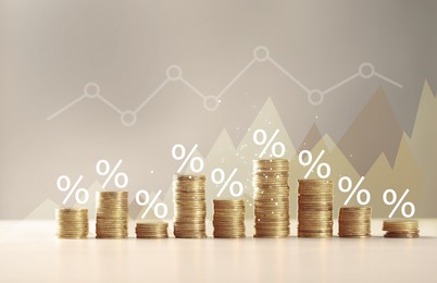 Image of Percent signs and graph above stacked coins against beige background