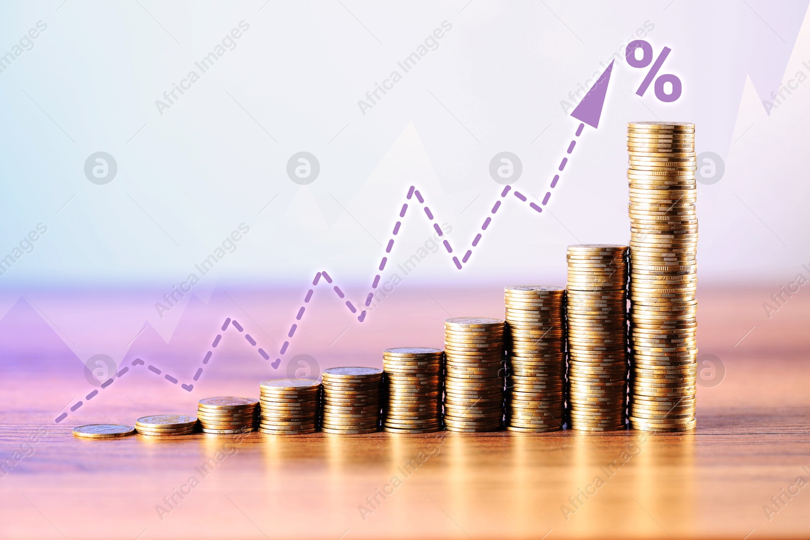 Image of Percent sign and arrow above stacked coins on wooden table