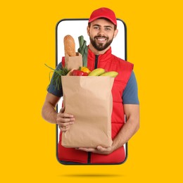 Image of Delivery service worker giving online order out of mobile phone against orange background. Man with paper bag full of food products