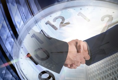 Image of Business people shaking hands, multiple exposure with buildings and clock. Success in partnership, deal, agreement