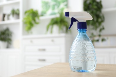 Photo of Houseplant care. Spray bottle on wooden table, closeup. Space for text