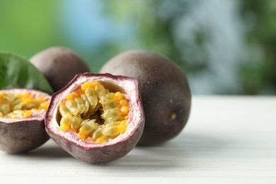 Photo of Fresh passion fruits on white wooden table outdoors, closeup. Space for text