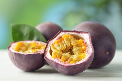 Photo of Fresh passion fruits on white wooden table outdoors, closeup
