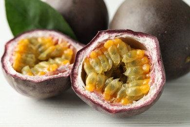 Photo of Fresh passion fruits on white wooden table, closeup