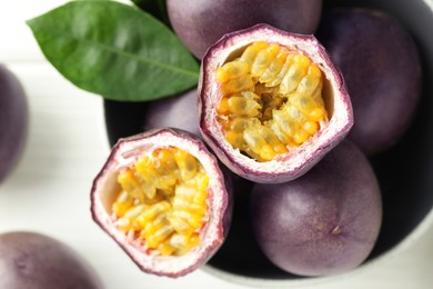 Photo of Fresh passion fruits in bowl on white table, top view