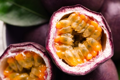 Photo of Fresh passion fruits and green leaf in bowl, top view