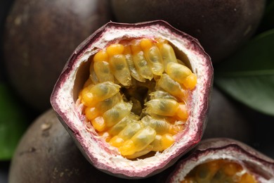 Photo of Fresh passion fruits and green leaf as background, top view