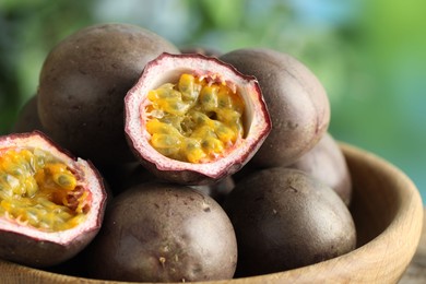 Photo of Fresh passion fruits in bowl outdoors, closeup