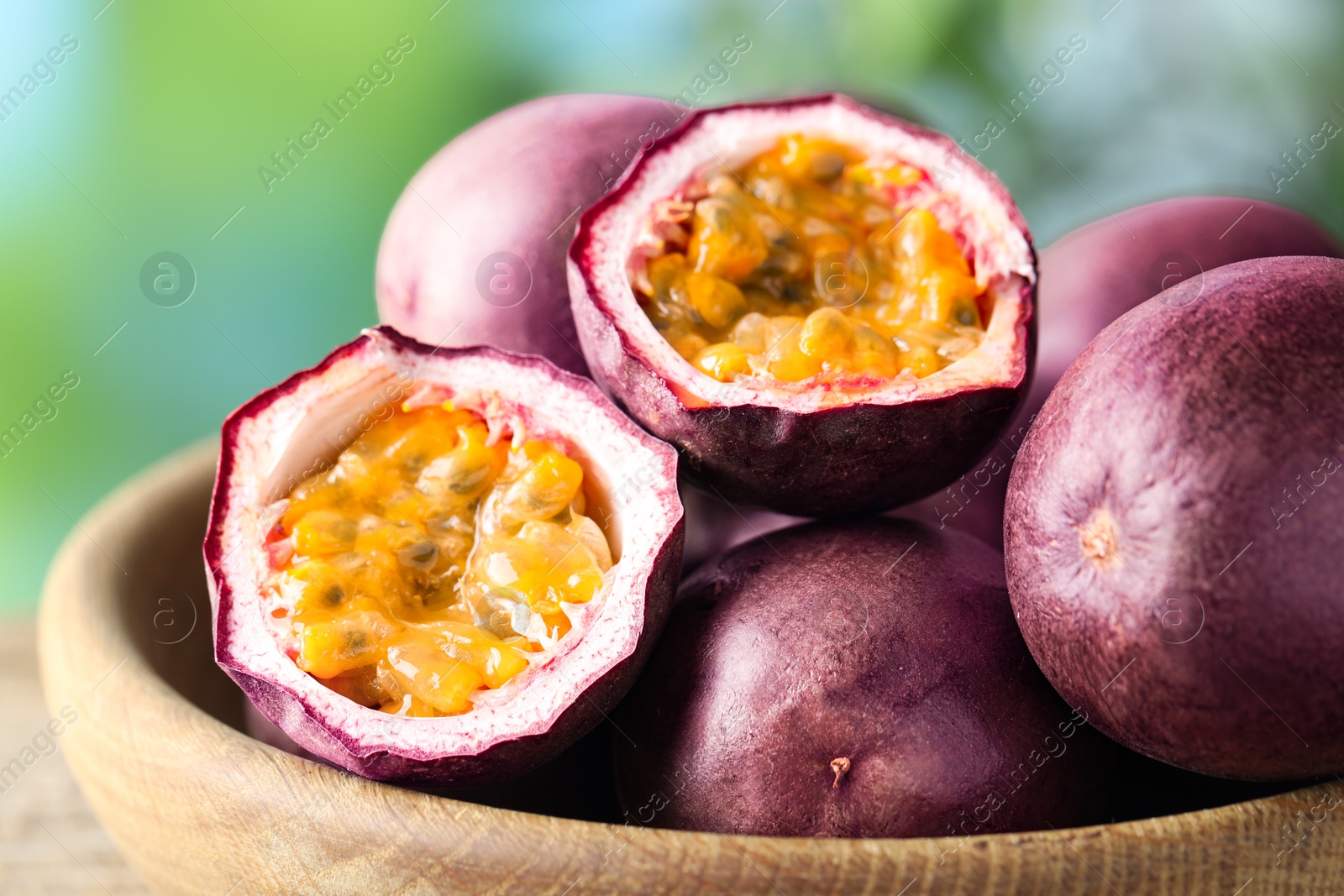 Fresh passion fruits in bowl outdoors, closeup Photo of Fresh passion fruits in bowl outdoors, closeup