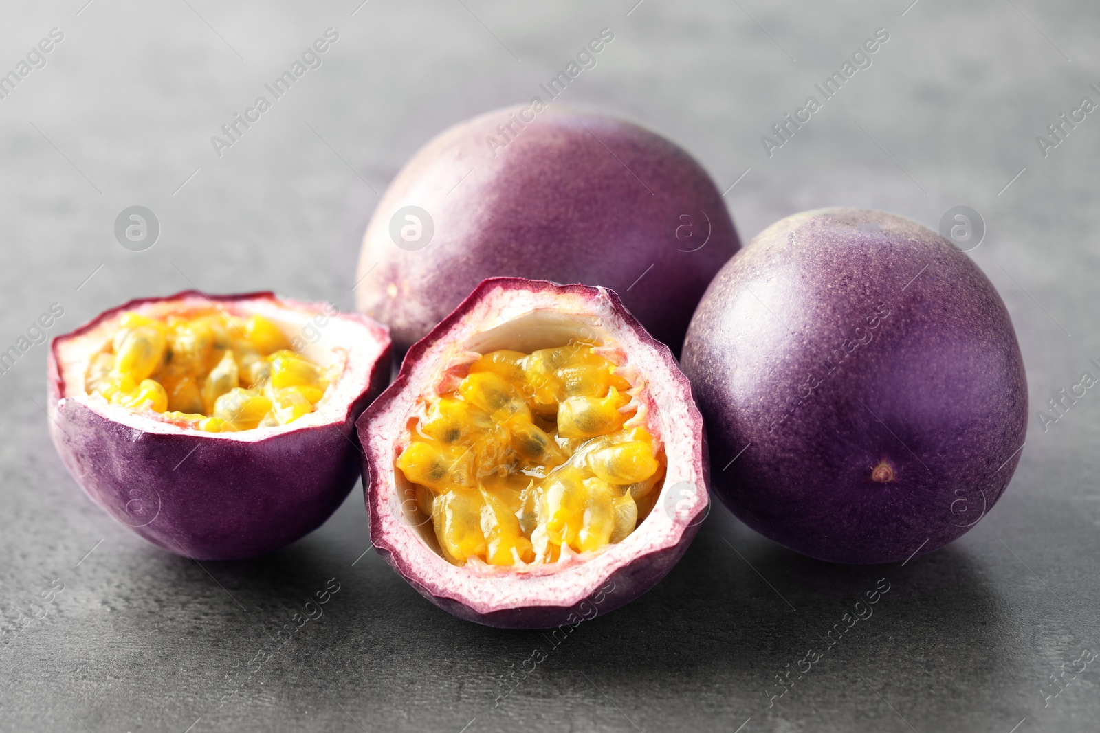 Fresh passion fruits on grey table, closeup Photo of Fresh passion fruits on grey table, closeup