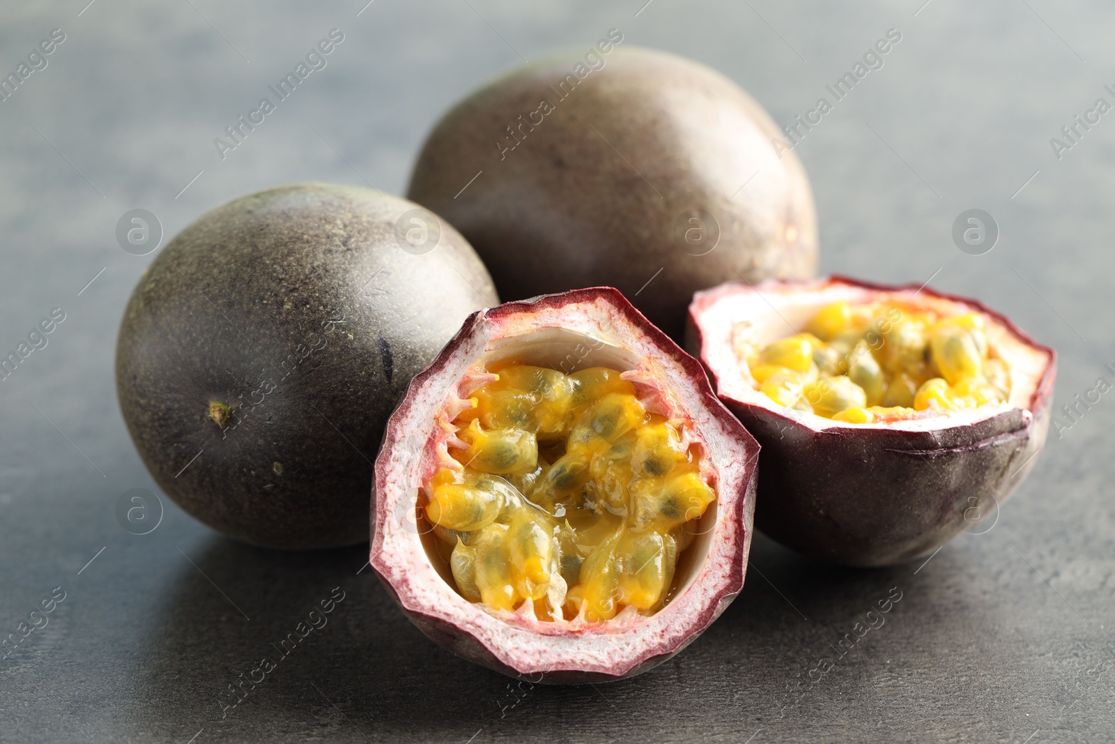 Fresh passion fruits on grey table, closeup Photo of Fresh passion fruits on grey table, closeup