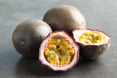 Photo of Fresh passion fruits on grey table, closeup