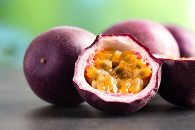 Photo of Fresh passion fruits on grey table outdoors, closeup