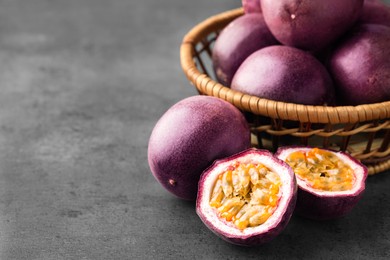 Photo of Fresh passion fruits on grey table, closeup. Space for text