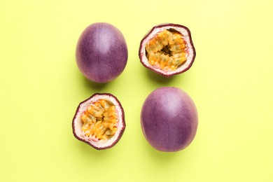 Photo of Fresh passion fruits on pale green background, flat lay