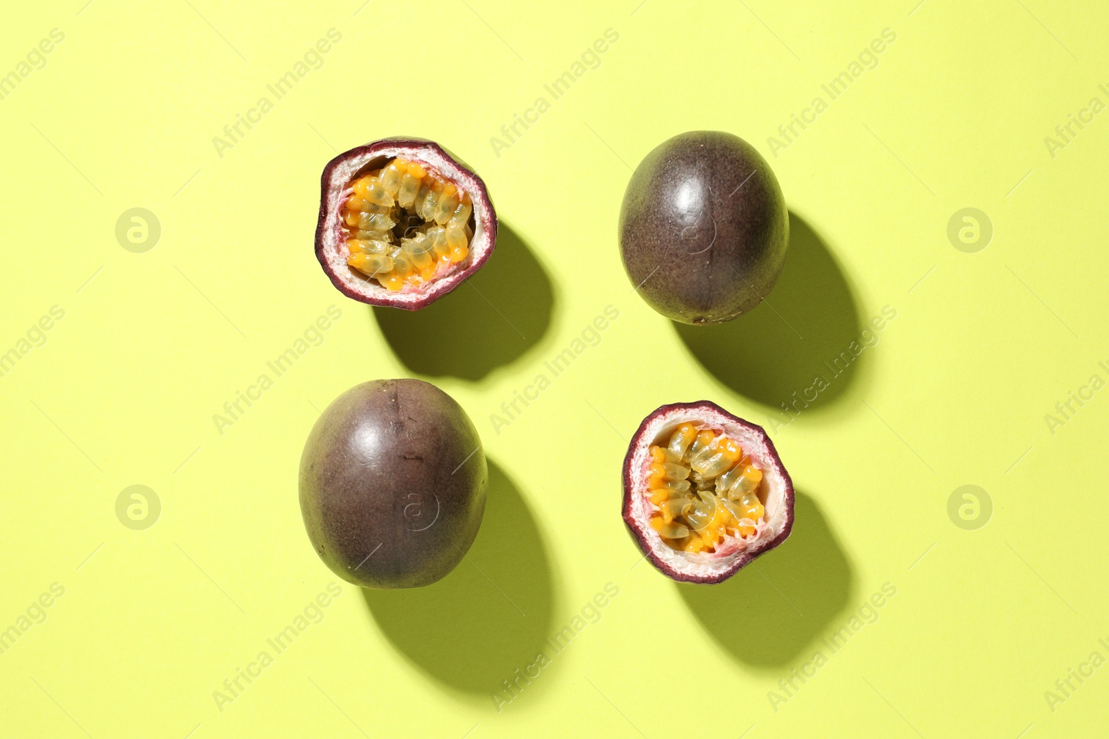 Photo of Fresh passion fruits on pale green background, flat lay