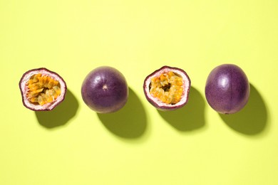 Photo of Fresh passion fruits on pale green background, flat lay