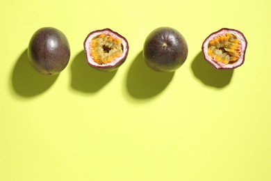 Photo of Fresh passion fruits on pale green background, flat lay. Space for text