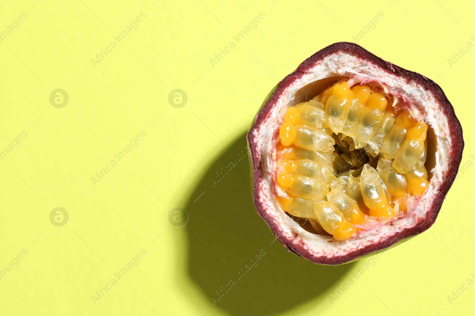 Half of fresh passion fruit on pale green background, top view. Space for text Photo of Half of fresh passion fruit on pale green background, top view. Space for text