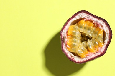 Photo of Half of fresh passion fruit on pale green background, top view. Space for text