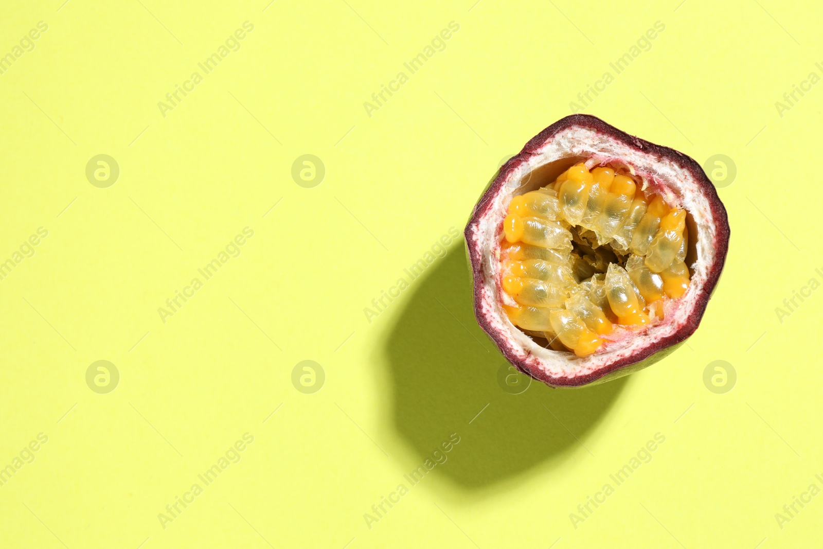 Half of fresh passion fruit on pale green background, top view. Space for text Photo of Half of fresh passion fruit on pale green background, top view. Space for text