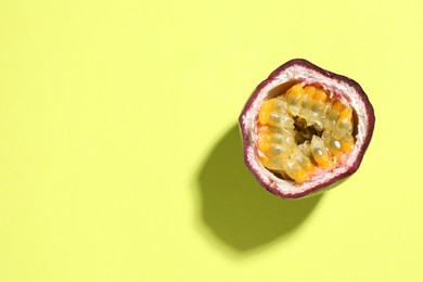 Photo of Half of fresh passion fruit on pale green background, top view. Space for text