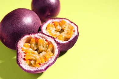 Photo of Fresh passion fruits on pale green background, closeup. Space for text
