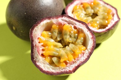 Photo of Fresh passion fruits on pale green background, closeup