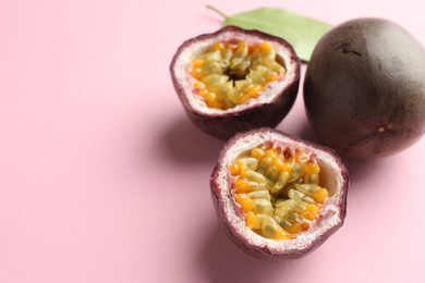 Photo of Fresh passion fruits and green leaf on pink background, closeup. Space for text