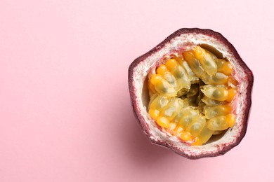 Photo of Half of fresh passion fruit on pink background, top view. Space for text