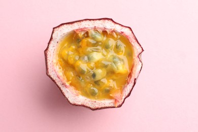 Photo of Half of fresh passion fruit on pink background, top view