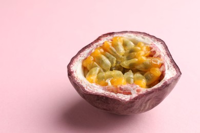 Photo of Half of fresh passion fruit on pink background, closeup. Space for text