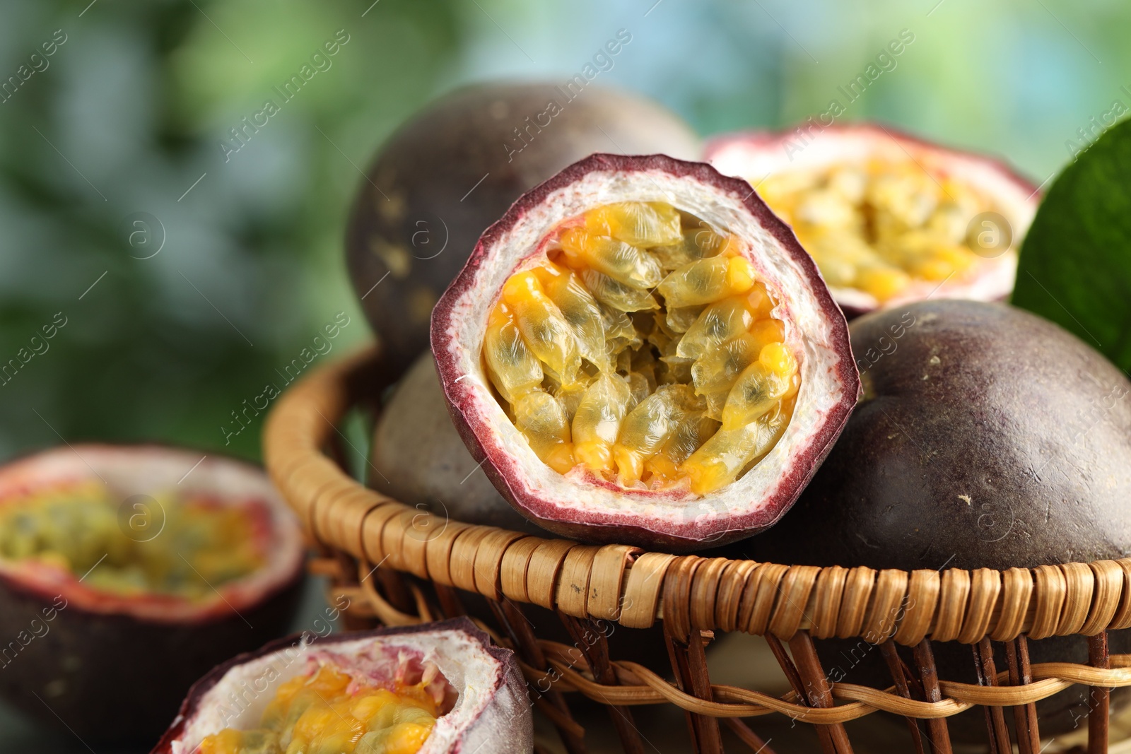 Fresh passion fruits in wicker basket on table outdoors, closeup Photo of Fresh passion fruits in wicker basket on table outdoors, closeup