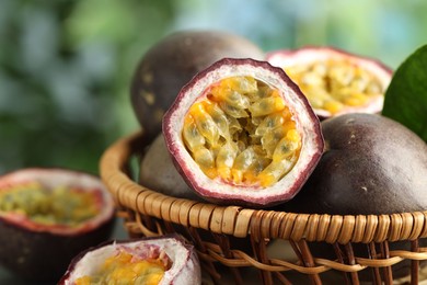 Photo of Fresh passion fruits in wicker basket on table outdoors, closeup