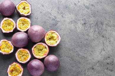 Photo of Fresh passion fruits on grey table, flat lay. Space for text