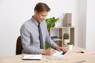 Photo of Business planning. Man with calendar at wooden table in office
